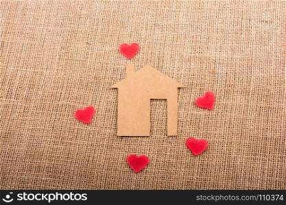 Heart shape around the paper house with a canvas background