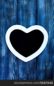 Heart shape chalkboard on the blue wooden wall