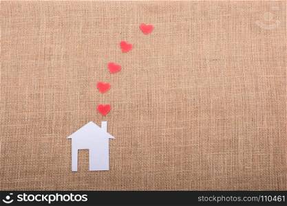 Heart shape coming out of chimney of paper house