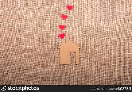 Heart shape coming out of chimney of paper house