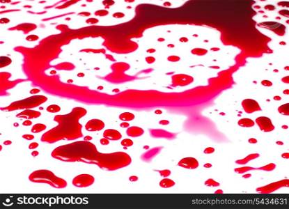 Heart shape from drops of red liquid isolated on white background