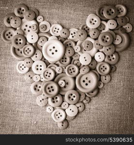 Heart shape from wooden buttons over canvas textile