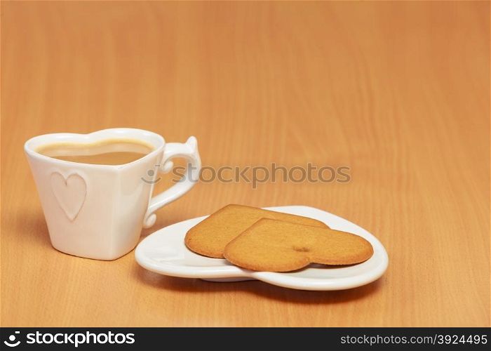 Heart shape gingerbread cookies and hot beverage tea or coffee on table.
