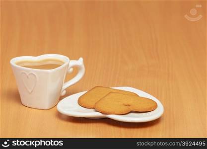 Heart shape gingerbread cookies and hot beverage tea or coffee on table.