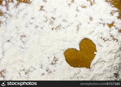 heart shape in a flour on wooden board