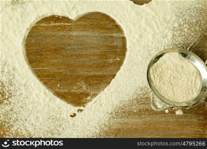 Heart shape in the sifted flour on the table