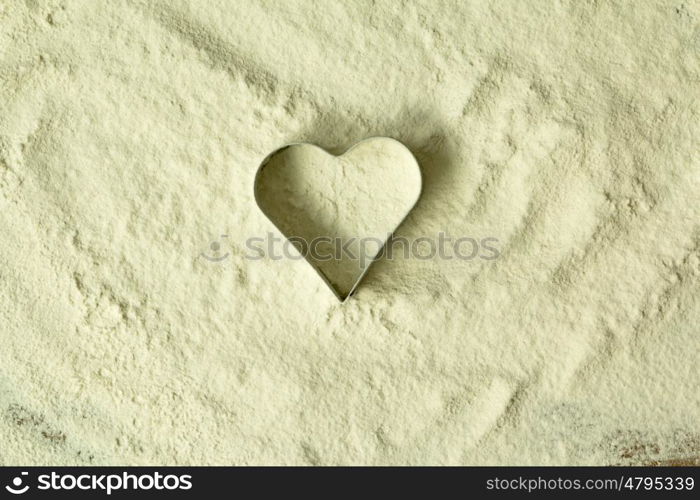 Heart shape in the sifted flour on the table