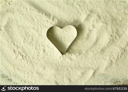 Heart shape in the sifted flour on the table