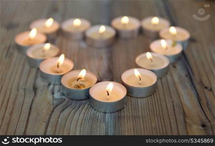 Heart shape made from nightlight candles on a wooden bacground