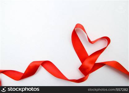 Heart shape made of red ribbon on white wooden Background. copy space Valentines and 8 March Mother Women's Day concept. Heart shape made of red ribbon on white wooden Background. copy space - Valentines and 8 March Mother Women's Day concept.