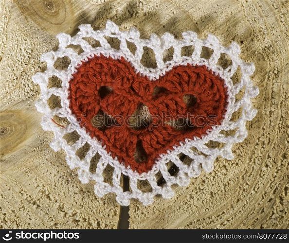 Heart shape made of red textile on wooden base