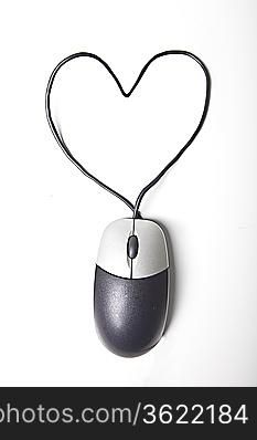 Heart shape made up of computer mouse wire over white background