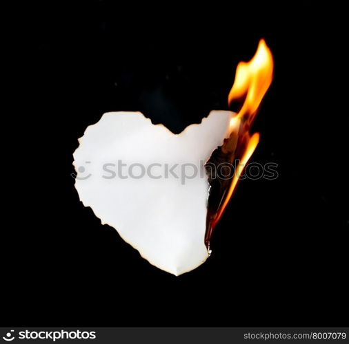 heart shape paper burning on black background