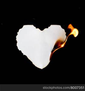 heart shape paper burning on black background