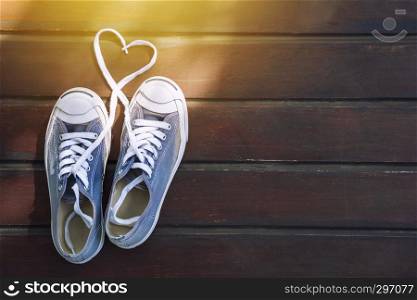 Heart shape with shoes string on wooden floor with sunlight. Love, wedding and valentine concept.