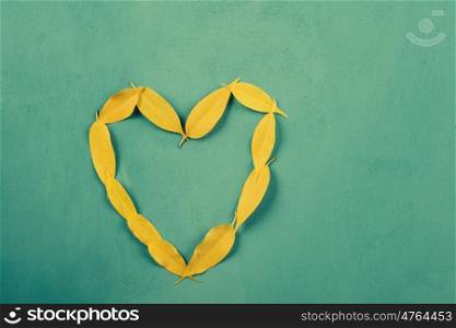 Heart Shape Yellow Autumn Leaves On Turquoise Wood Table
