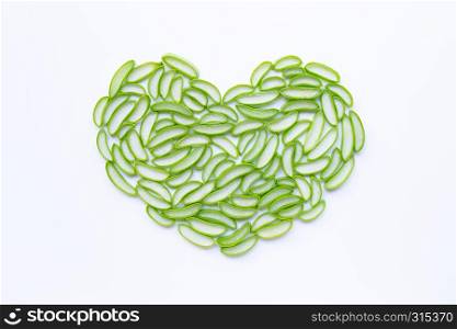 Heart shaped aloe vera slices on white background.