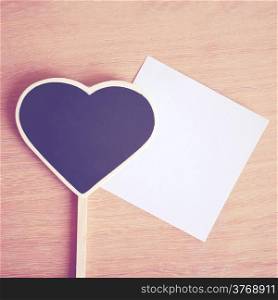 Heart shaped blackboard and note paper with copy space, retro filter effect