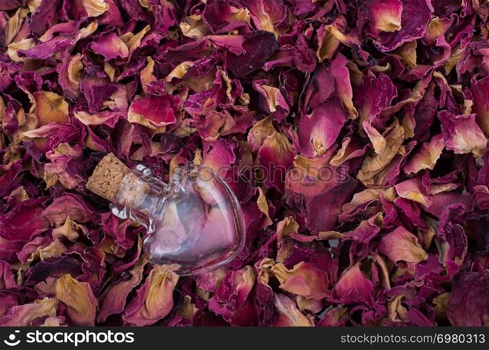 Heart shaped bottles on dry rose petal background