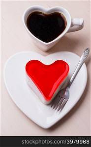 Heart shaped coffee cup and jelly cake on wooden kitchen background.