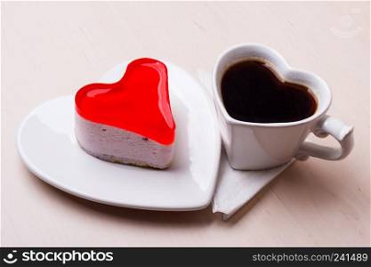 Heart shaped coffee cup and jelly cake on wooden kitchen table.