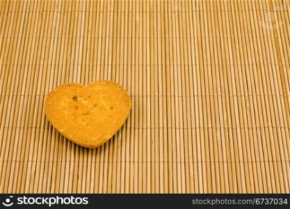 heart shaped cookie on striped bamboo tablecloth