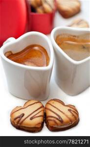 heart shaped cream cookies on red heart metal box and couple of espresso coffee cups