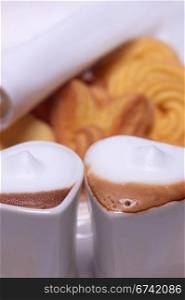 heart shaped espresso coffee cappuccino cups with assortment of pastry on background valentine day treat