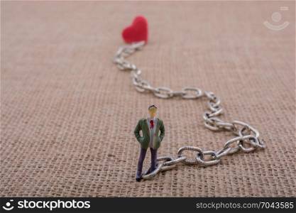 Heart shaped object attached to a man figurine on canvas