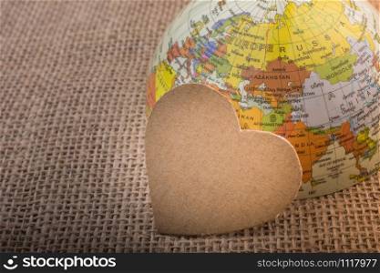 Heart shaped object by a model globe on canvas