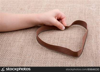 Heart shaped object in hand on a canvas background