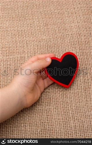 Heart shaped object in hand on canvas