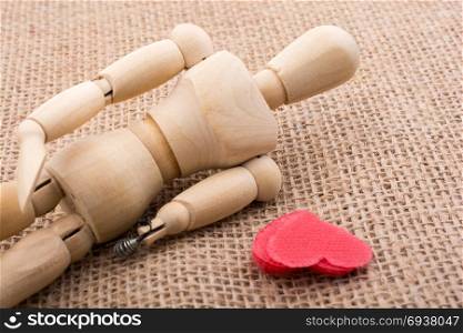 Heart shaped object in the hand of a wooden man toy