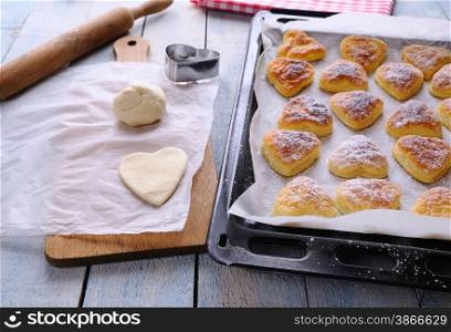 Heart-shaped puff pastry for valentines day over wooden table