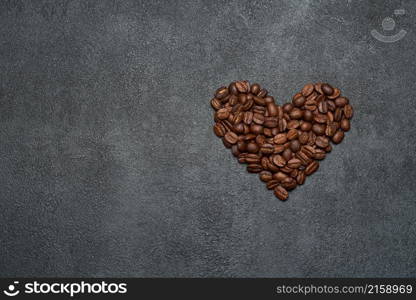 Heart shaped roasted coffee beans on dark concrete background.. Heart shaped roasted coffee beans on dark concrete background