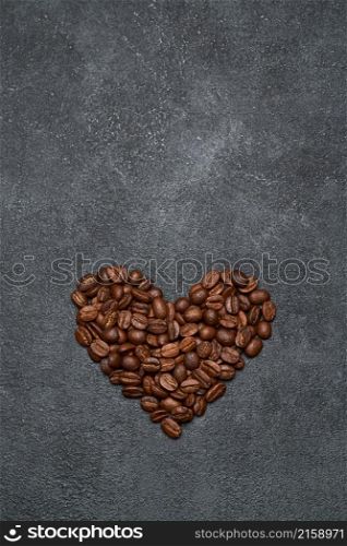Heart shaped roasted coffee beans on dark concrete background.. Heart shaped roasted coffee beans on dark concrete background