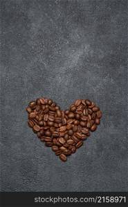 Heart shaped roasted coffee beans on dark concrete background.. Heart shaped roasted coffee beans on dark concrete background