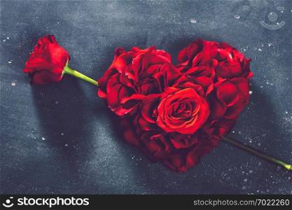 Heart-shaped roses and rose flower on stone background. Valentine&rsquo;s Day. Symbol of love and romance.. Heart-shaped roses and rose flower.