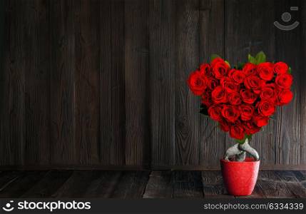 Heart shaped roses. Heart shaped red roses on tree on wooden background