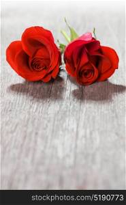 Heart shaped roses. Two heart shaped red roses on wooden background, Valentines day
