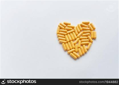 Heart shaped yellow pills, health and heart problems. Medicine and healthcare concept. Place for an inscription. Heart shaped yellow pills, health and heart problems. Medicine and healthcare concept. Place for an inscription.