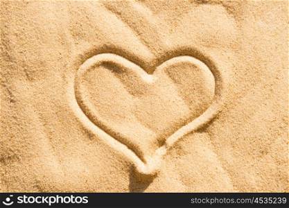 Heart sign drawing on the beach sand