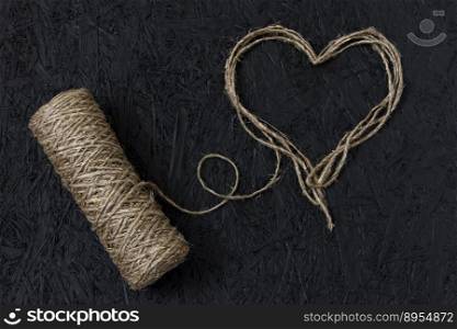 Heart thread on February 14, Valentine’s Day on a black background. Valentines day greeting card. Heart of thread. String of twine.. Heart thread on February 14, Valentine’s Day on a black background. Valentines day greeting card. Heart of thread. String of twine