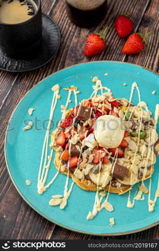 Heart waffle with banana and strawberry with gummy candy and ice cream on it.