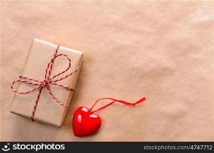 Heart with handmade gift box wrapped with craft paper and red bow for Valentine's day