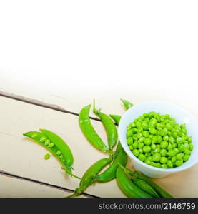 hearthy fresh green peas over a rustic wood table