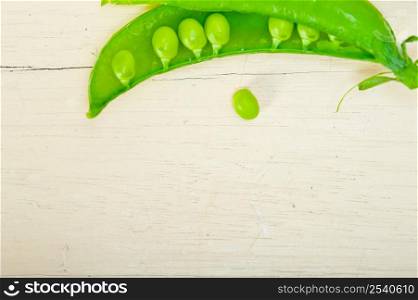 hearthy fresh green peas over a rustic wood table