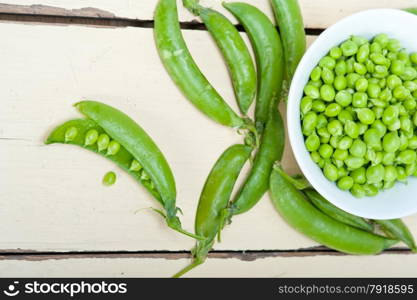 hearthy fresh green peas over a rustic wood table