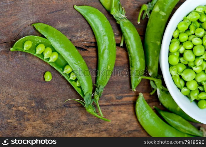 hearthy fresh green peas over a rustic wood table