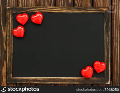 hearts and blackboard on the wooden background